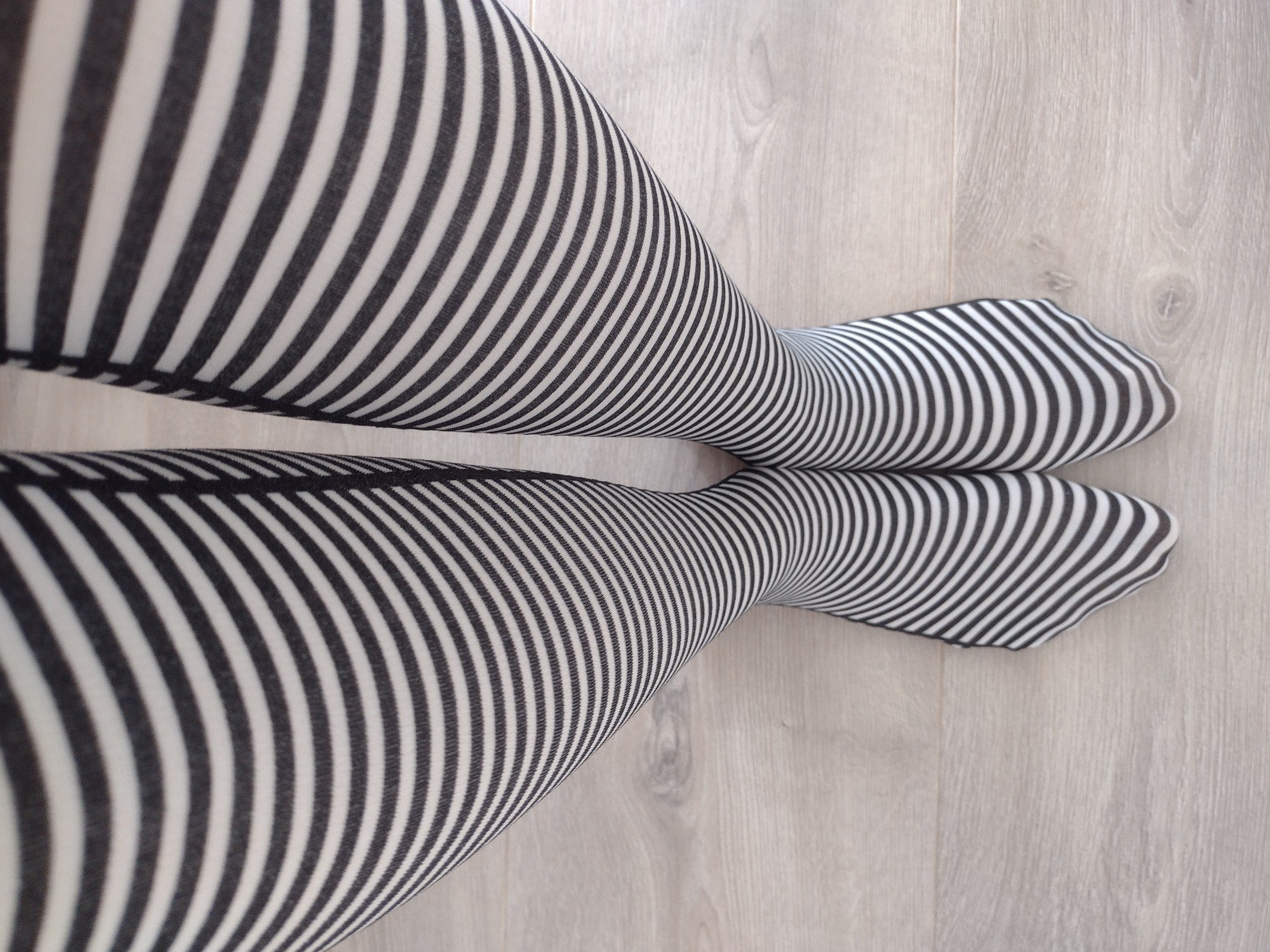 Full leg view of black and cream fine horizontal stripe tights