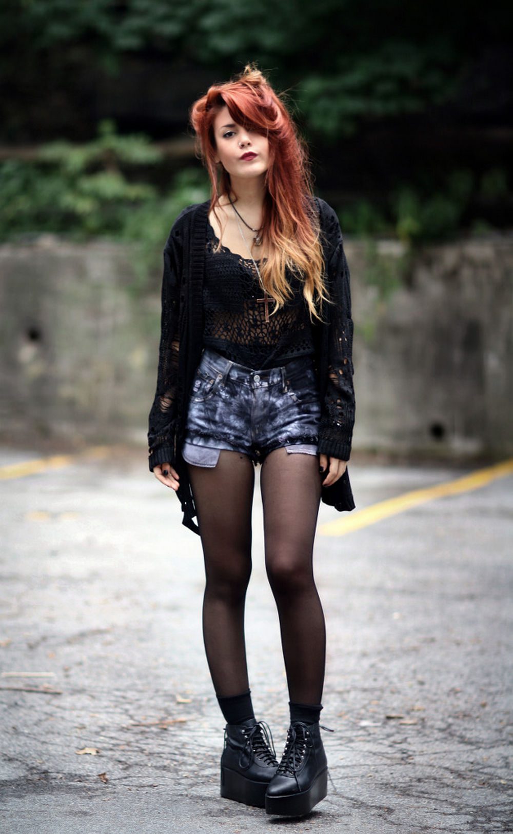 Black sheer tights with tie-dye denim shorts, a sheer crochet top, and chunky platform boots