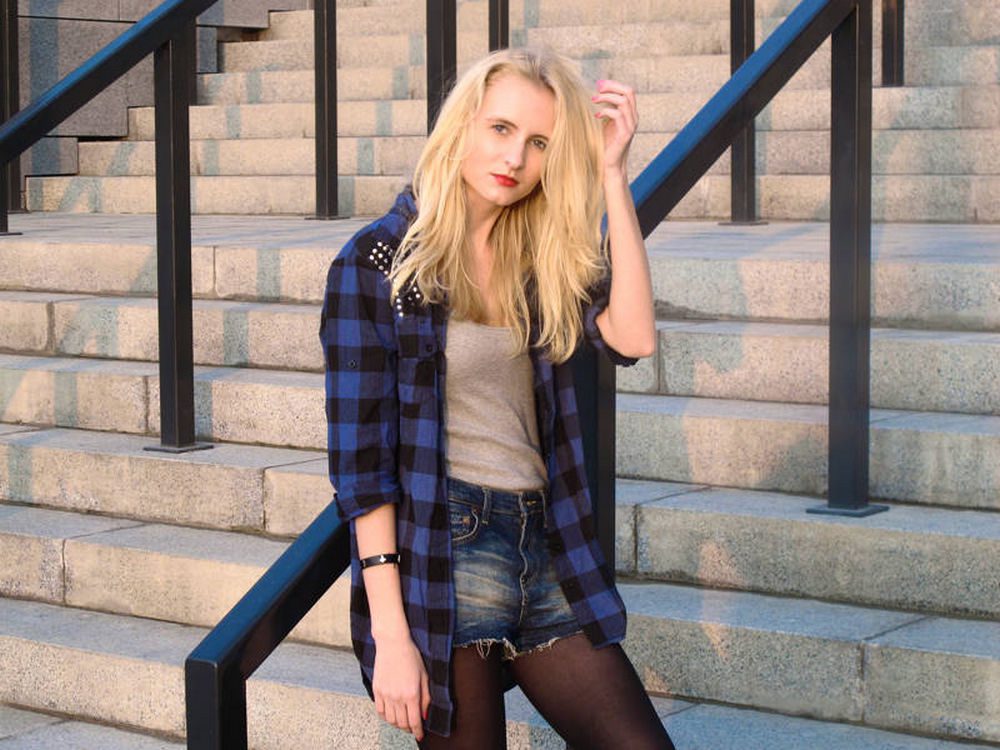 Black sheer tights with denim shorts and an oversized blue plaid flannel shirt