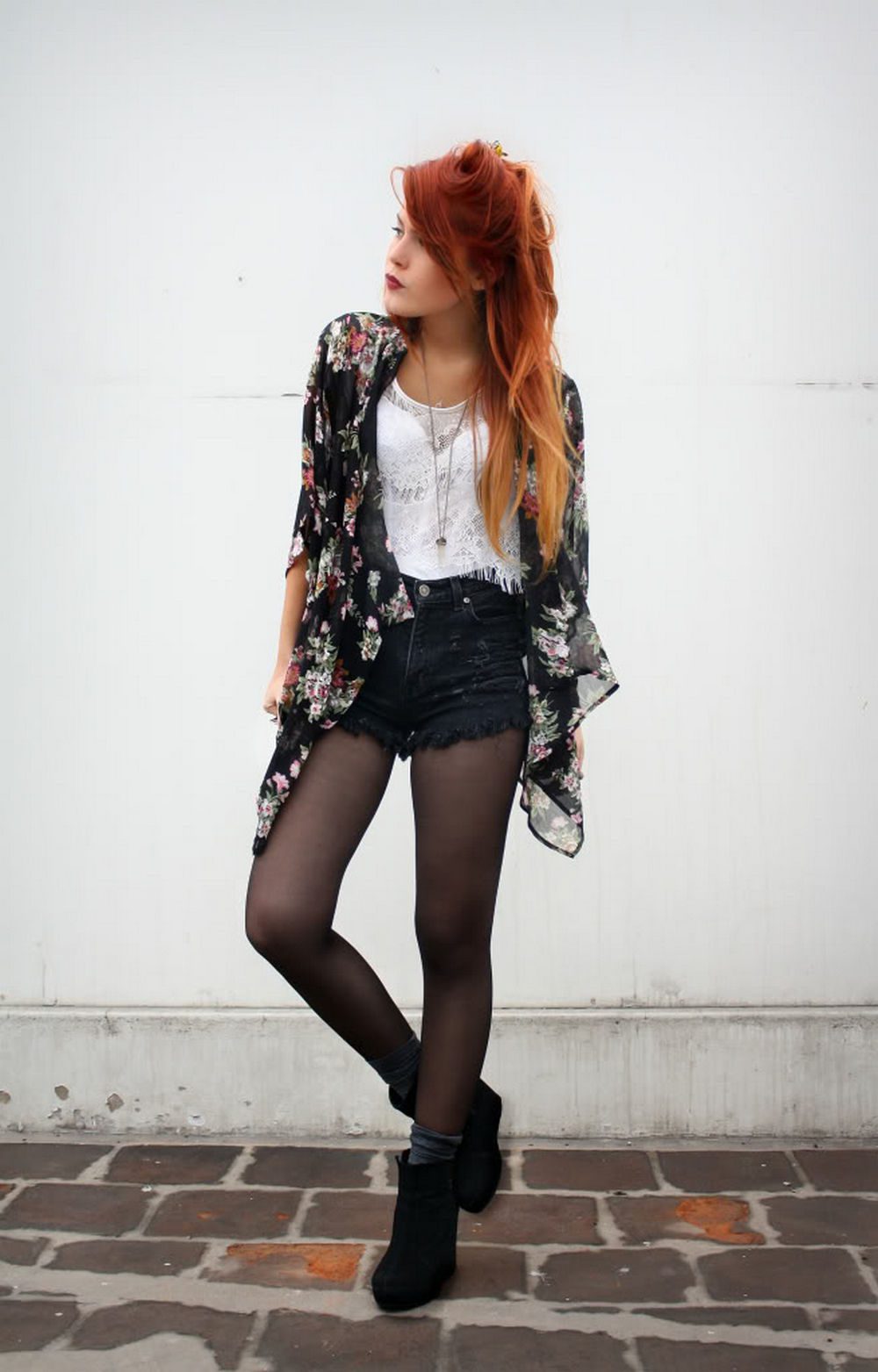 Black sheer tights with a floral kimono, white lace top, denim shorts, and ankle boots