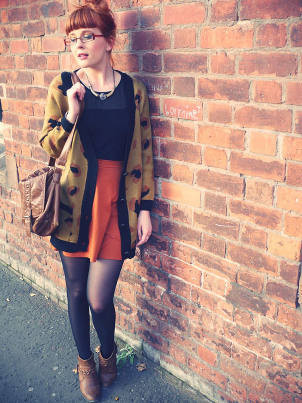 Black sheer tights with a burnt orange skirt and an oversized leopard-print cardigan