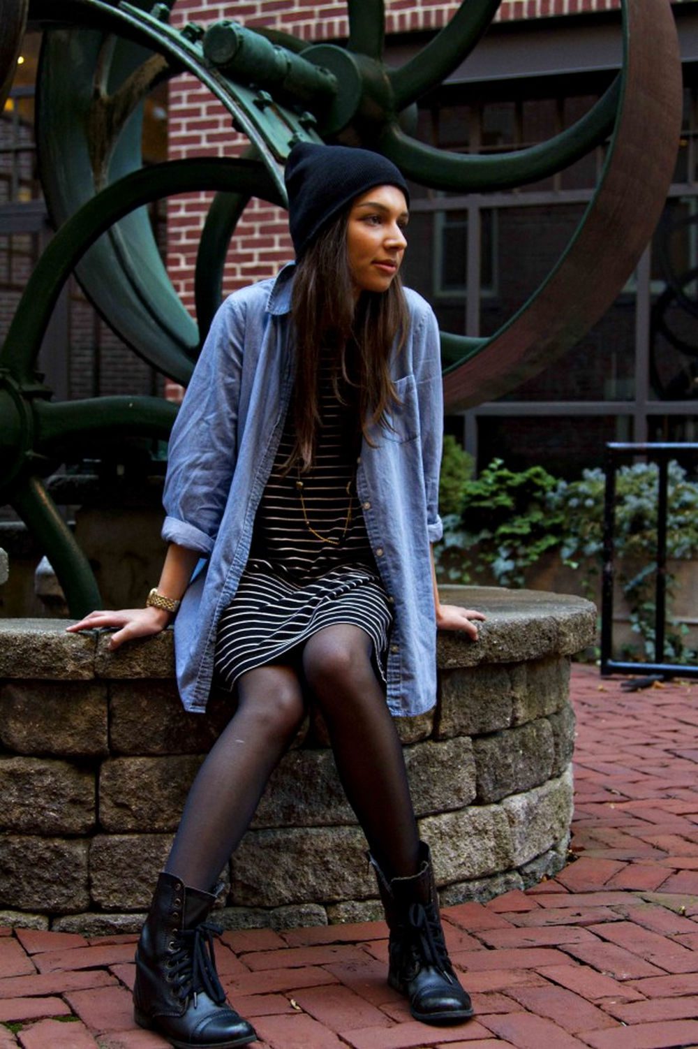 Black sheer tights with a striped mini dress, an oversized chambray shirt, and lace-up boots