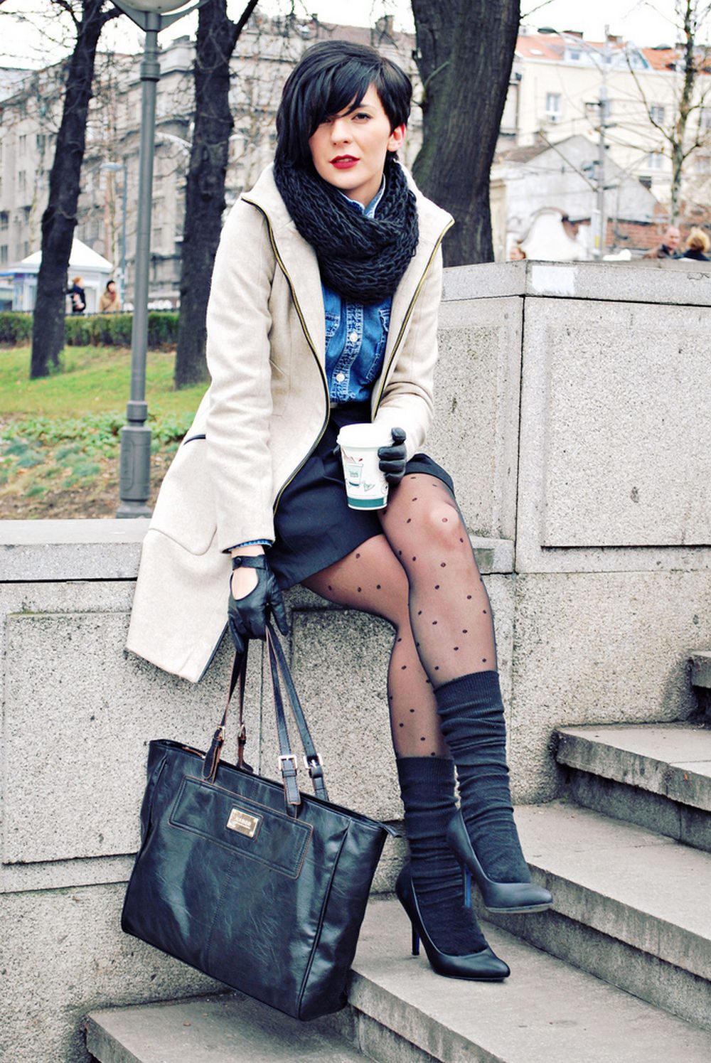 Grey socks layered over black polka dot tights with cream coat and ankle boots
