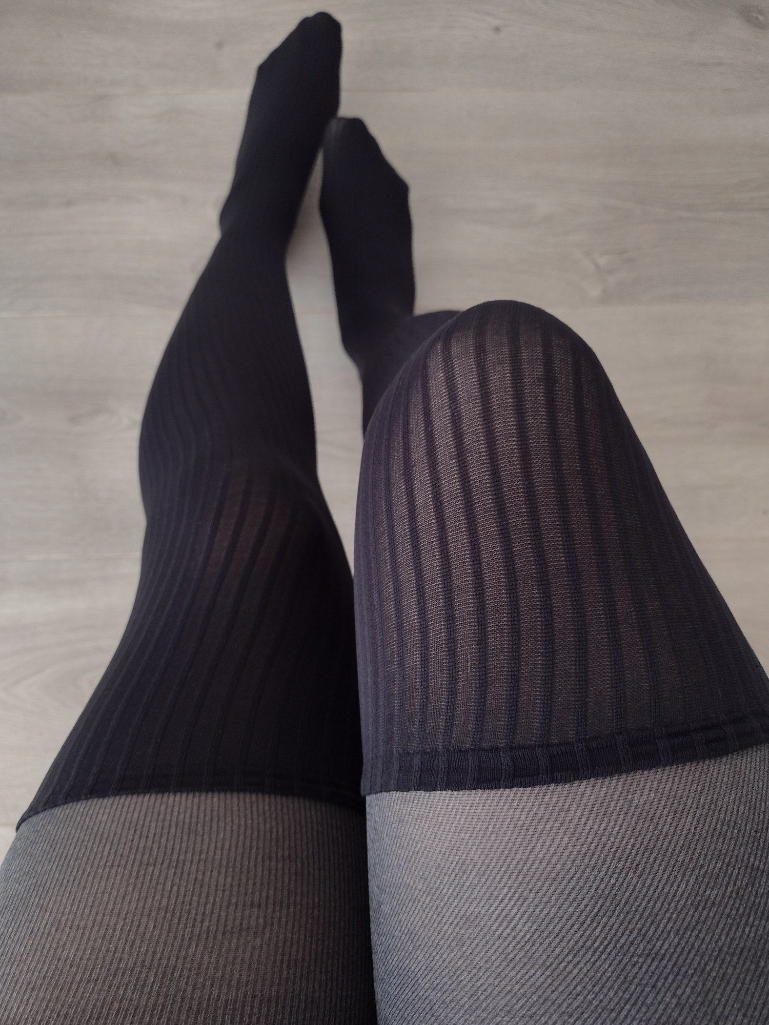 Charcoal pinstripe tights with a faux thigh-high ribbed knit panel, worn, close-up on legs