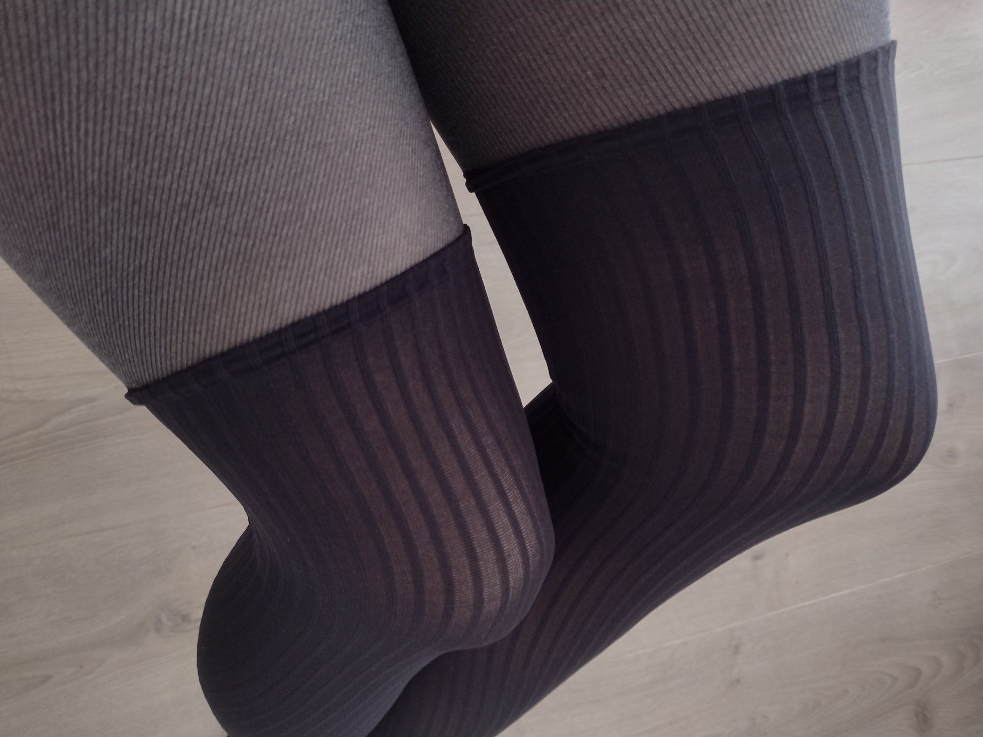 Close-up of charcoal pinstripe faux thigh-high tights showing the ribbed knit transition