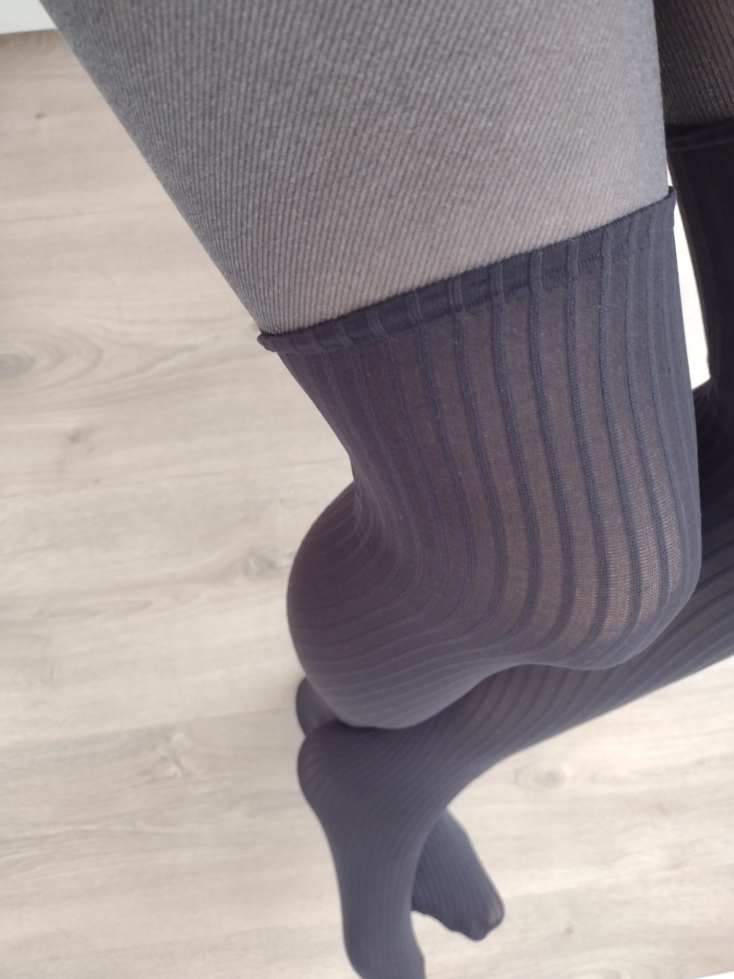 Charcoal pinstripe faux thigh-high tights worn, showing the ribbed knit thigh transition up close