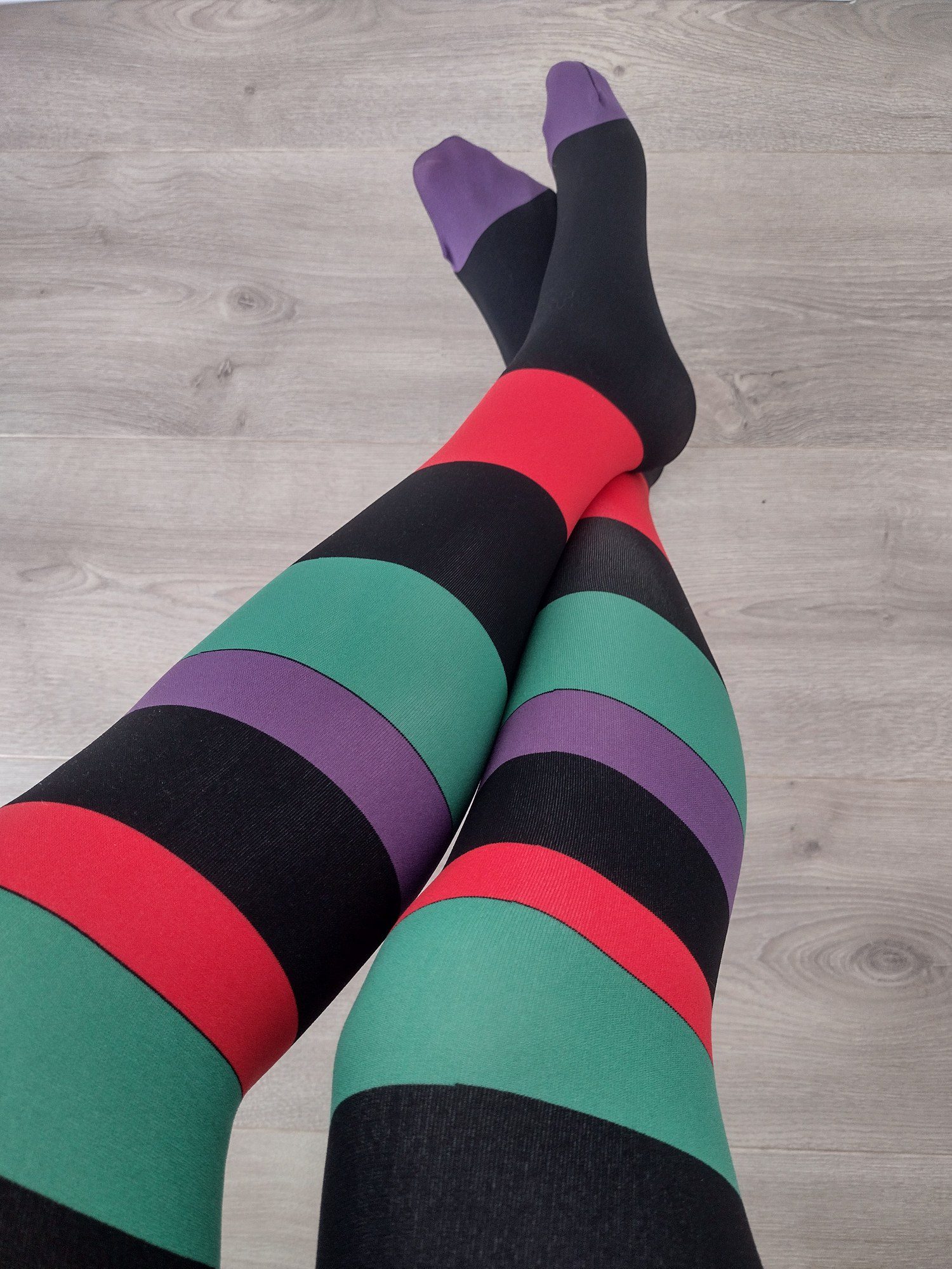 Full leg view of jewel-tone horizontal stripe tights with purple toes