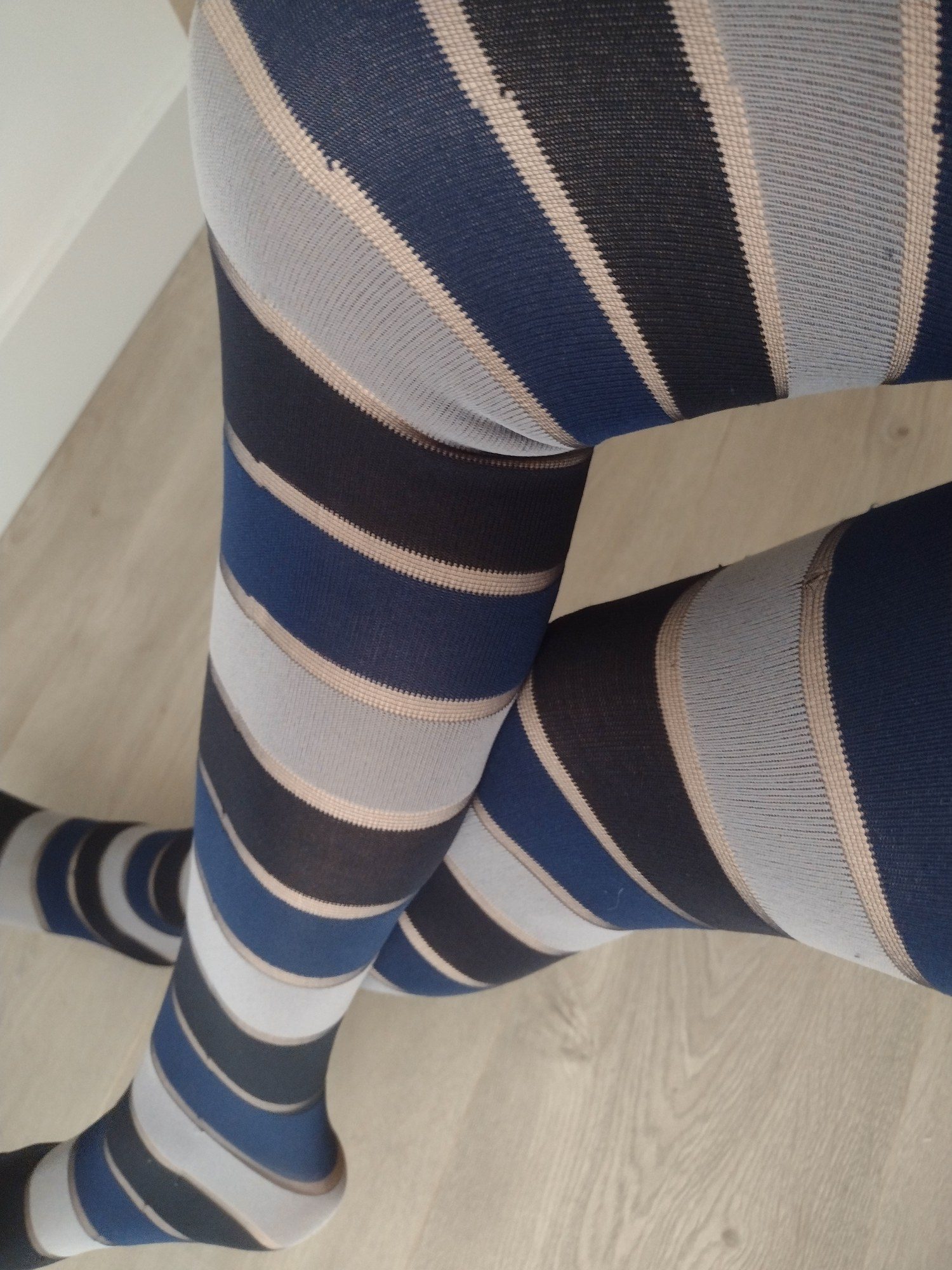 Navy, blue, grey and beige horizontal stripe tights, worn on legs