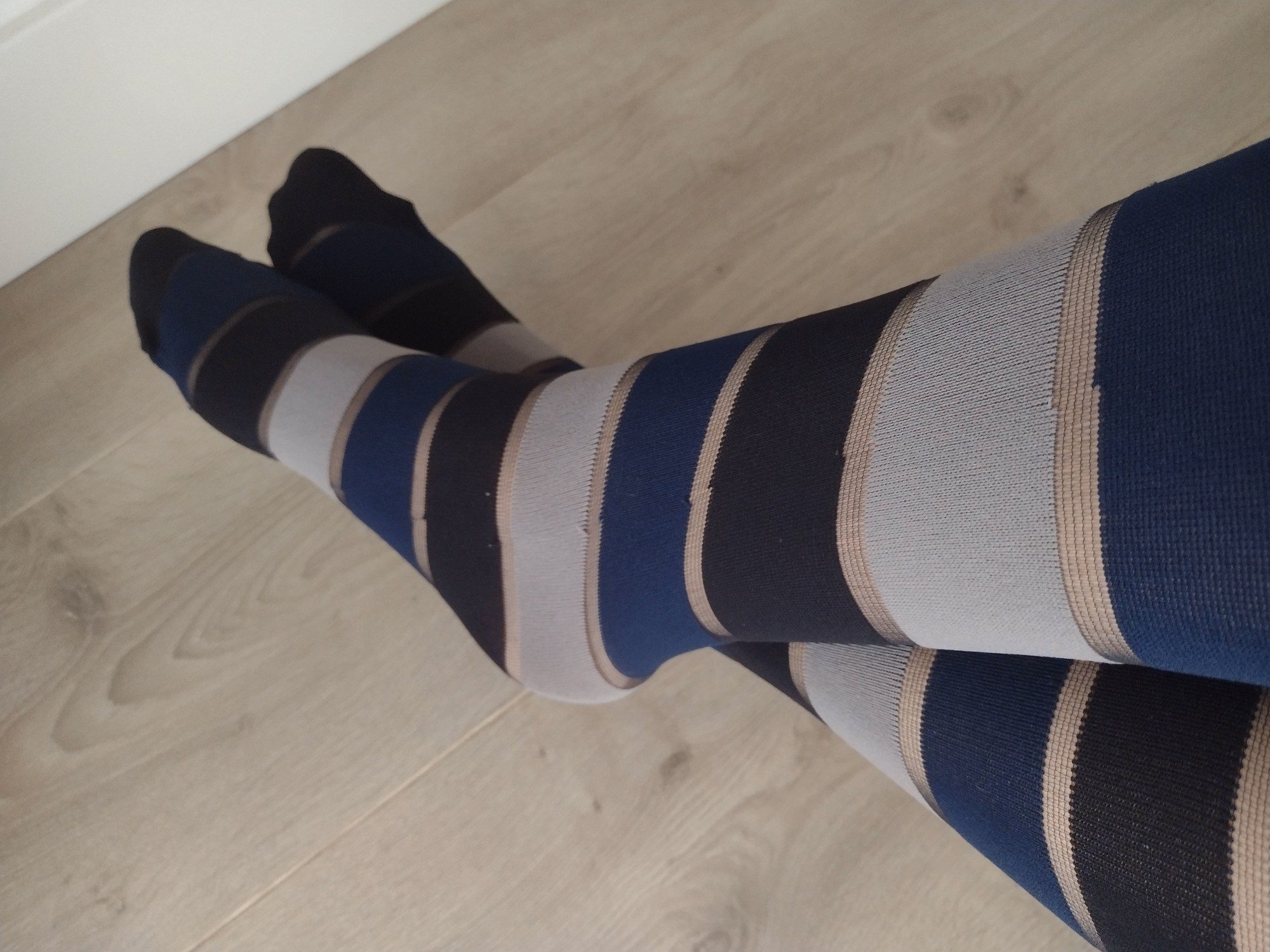 Close-up of navy blue horizontal stripe tights worn on legs