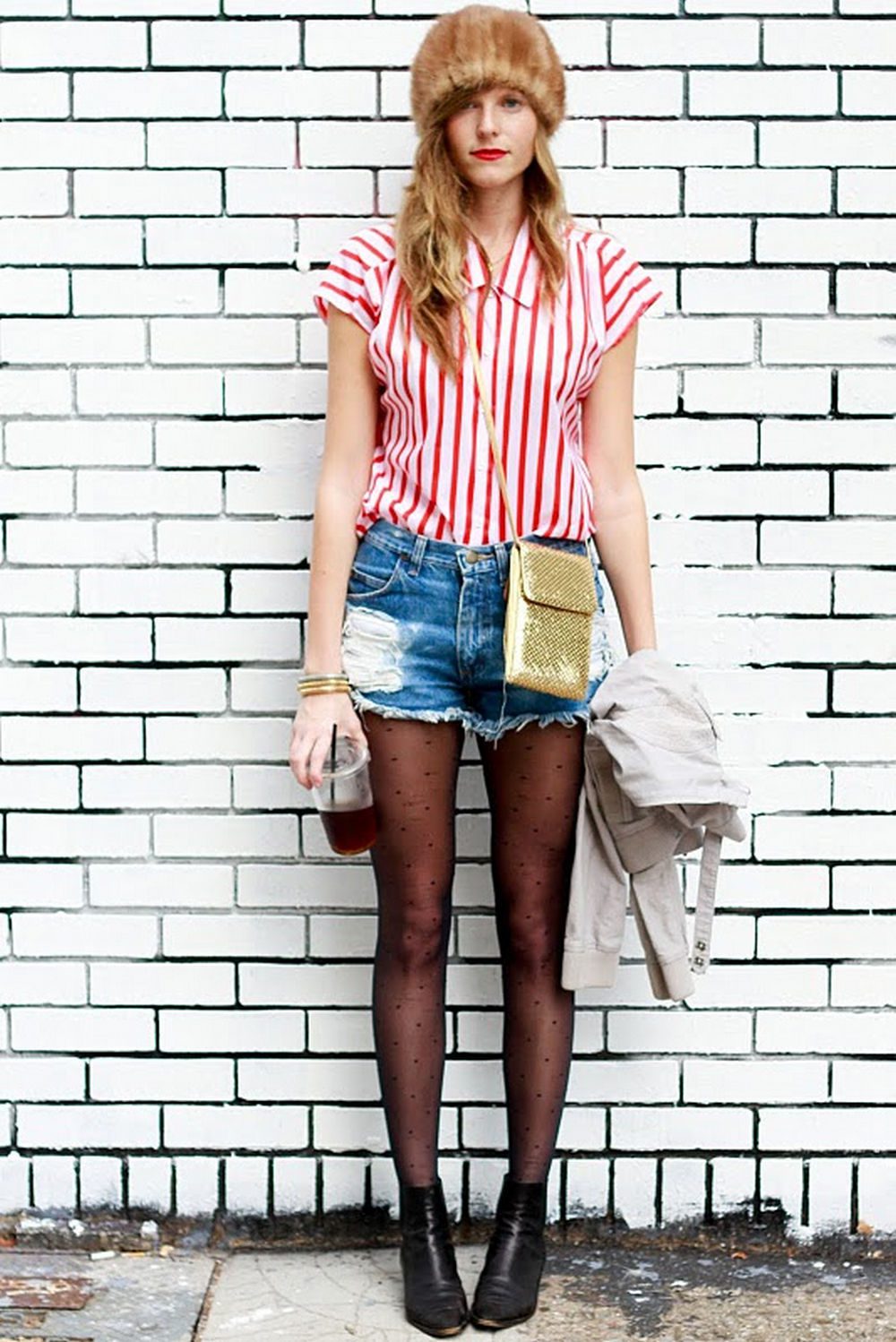 Denim shorts over black polka dot tights with striped shirt and fur hat