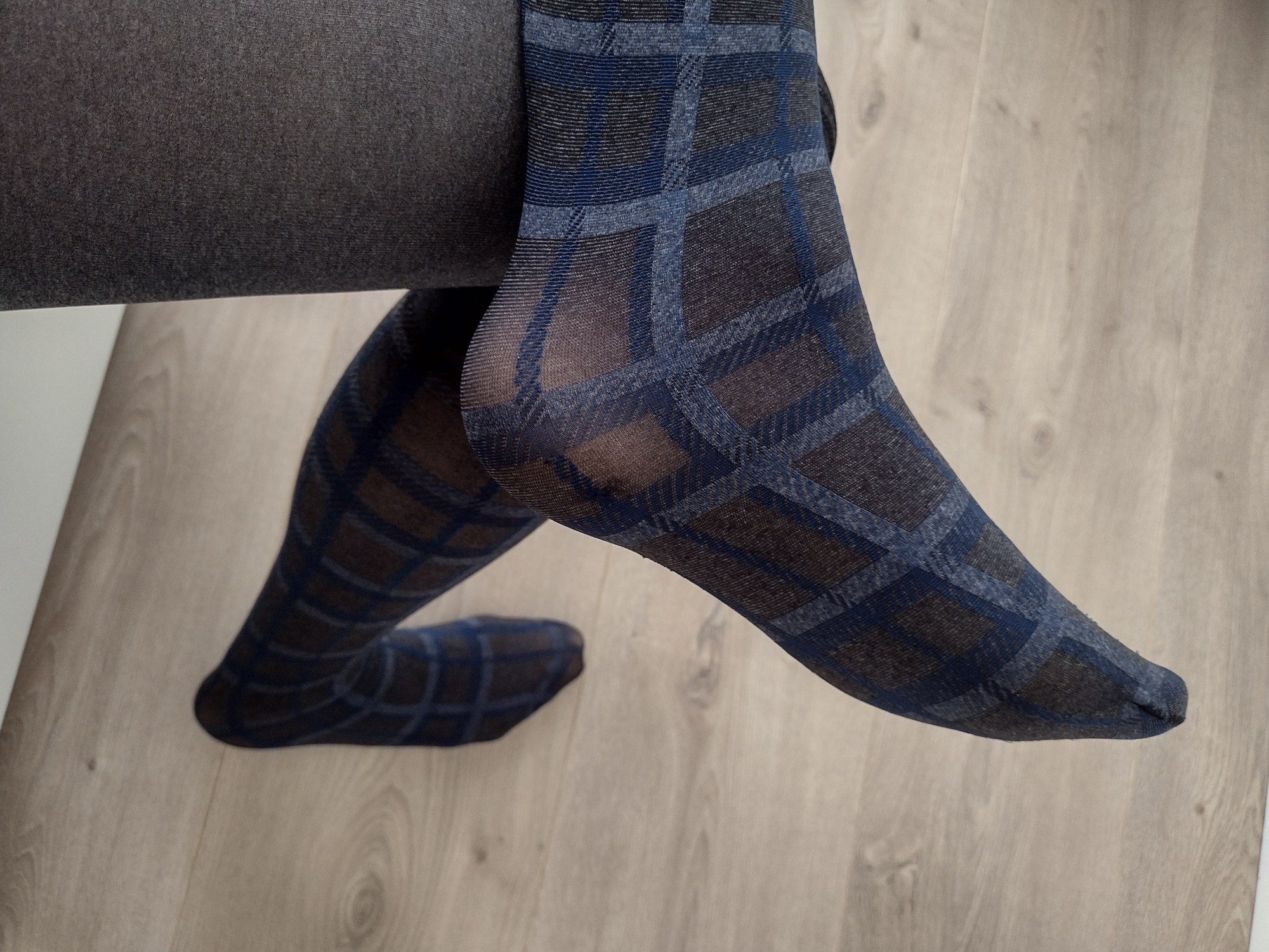 Close-up of windowpane check tights transitioning into a black plaid faux-stocking panel