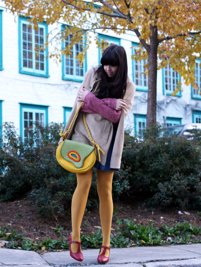 Mustard yellow tights with a tan trench coat, burgundy sweater, and red mary-jane heels, carrying a green and yellow floral bag