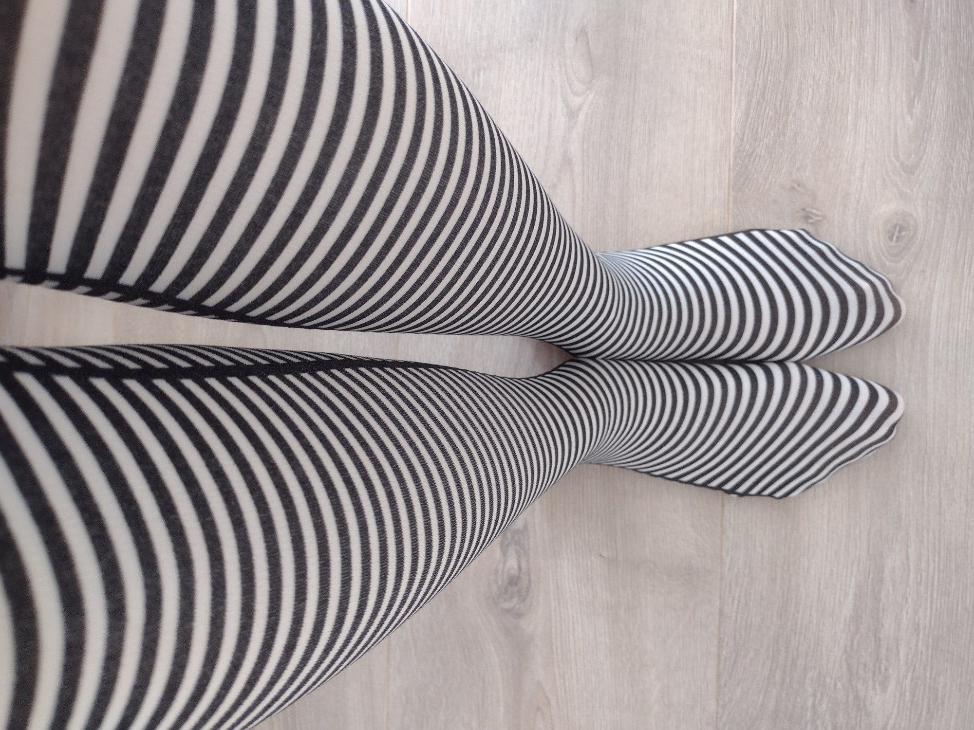 Full leg view of black and cream fine horizontal stripe tights
