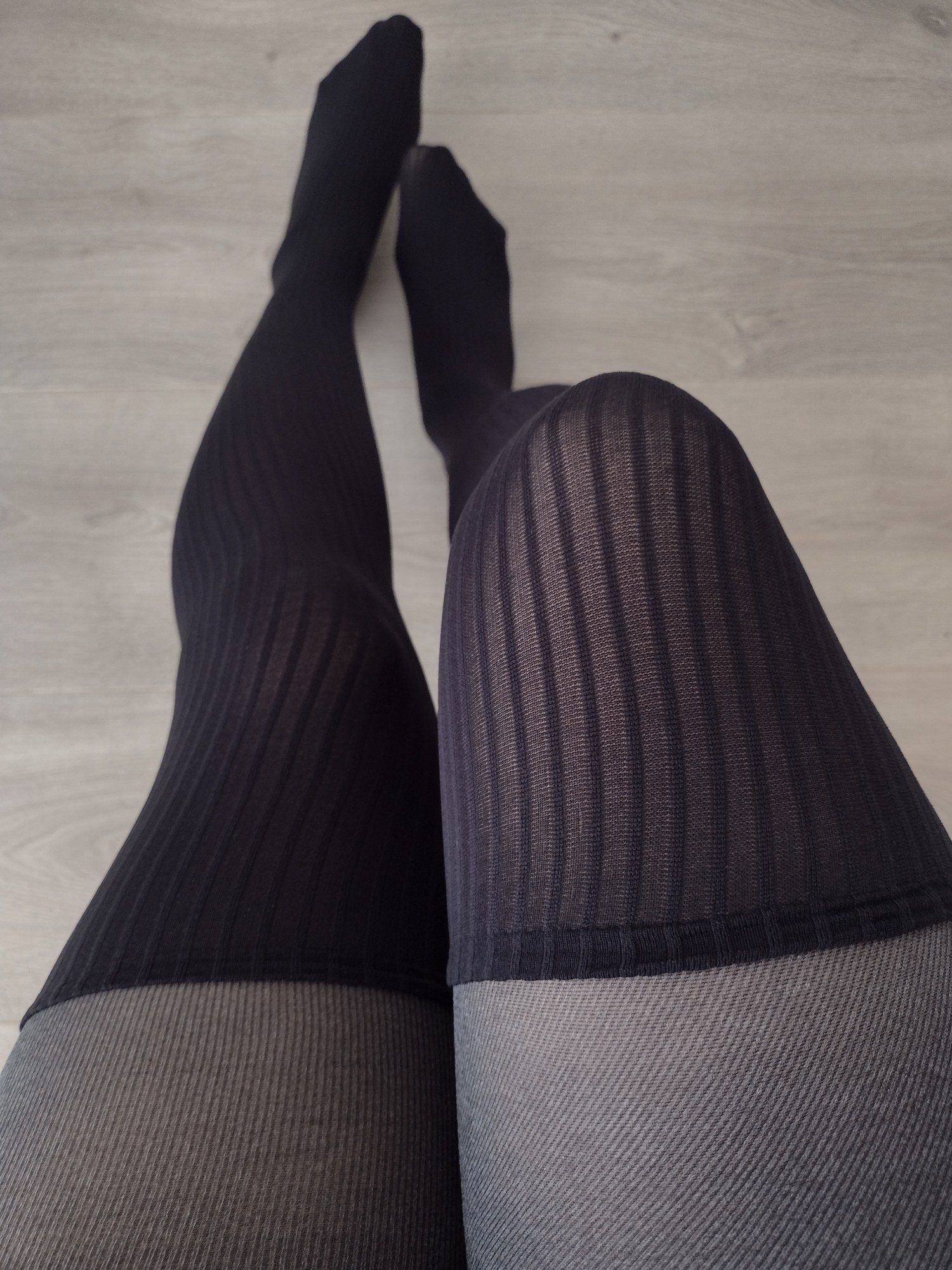 Charcoal pinstripe tights with a faux thigh-high ribbed knit panel, worn, close-up on legs