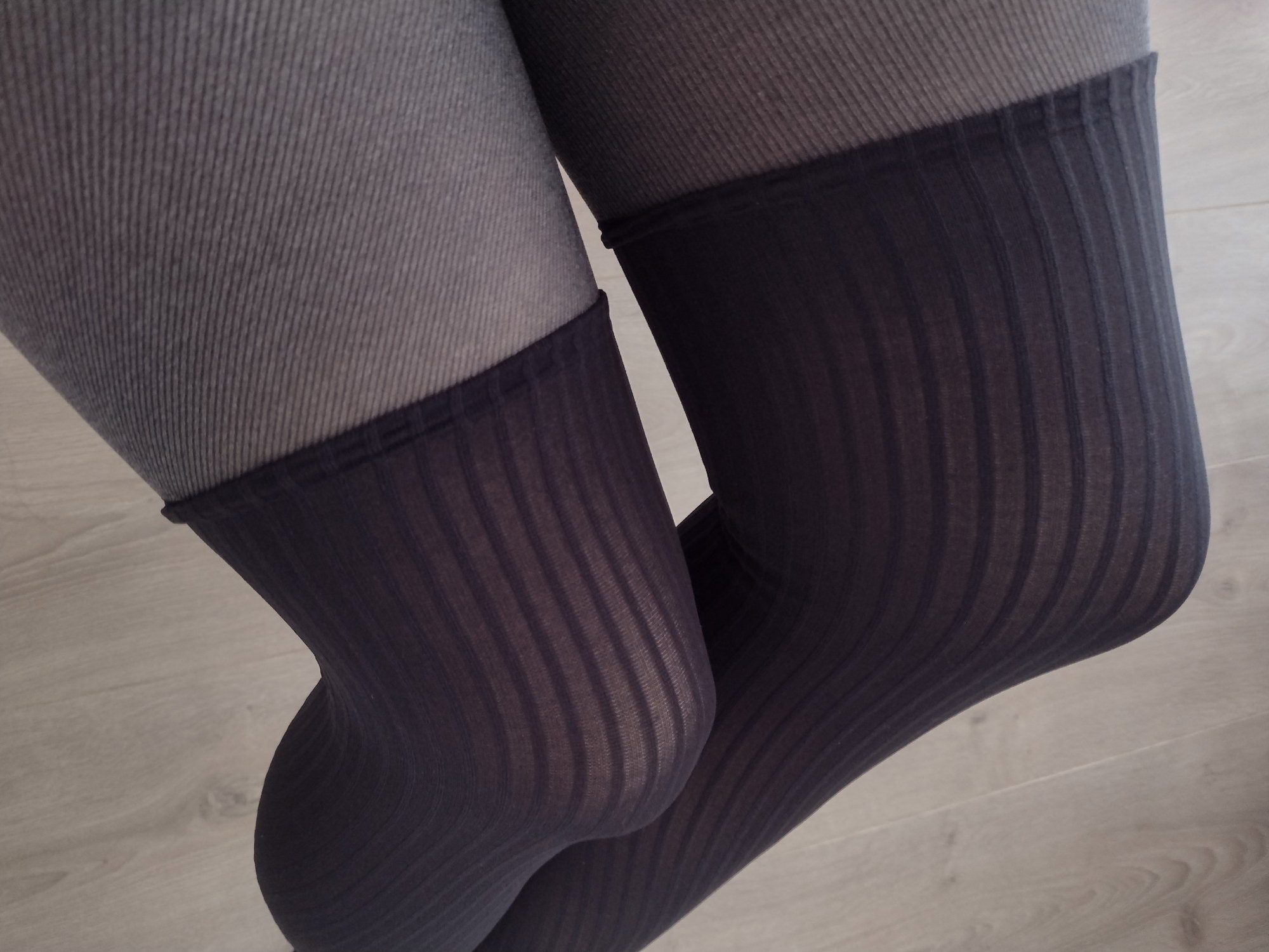 Close-up of charcoal pinstripe faux thigh-high tights showing the ribbed knit transition