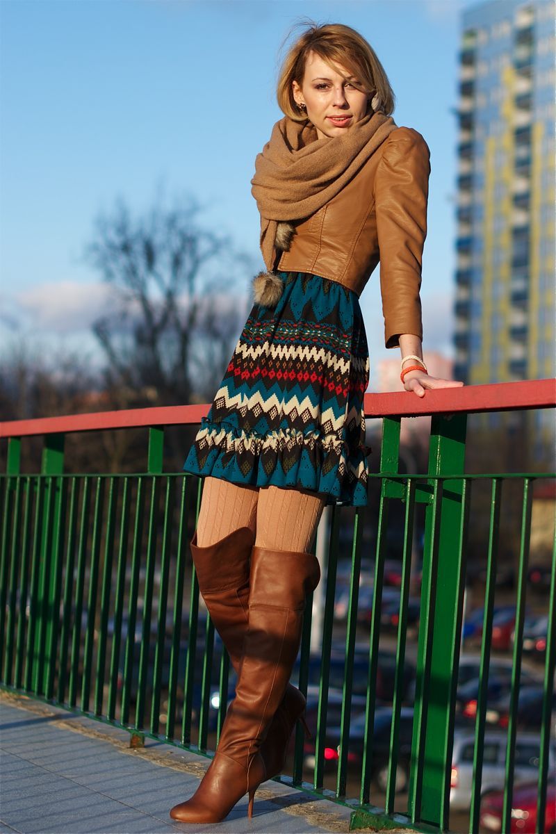 Beige ribbed tights with tall cognac leather boots, a patterned teal skirt and a camel leather jacket