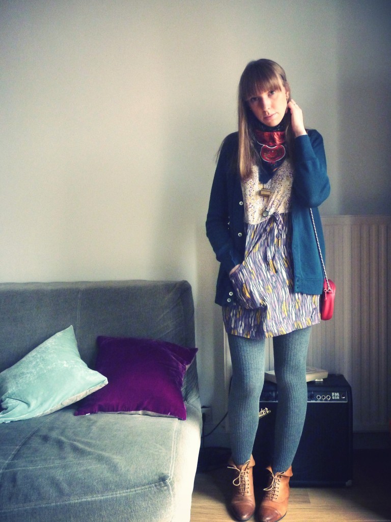Soft blue wool tights with cognac lace-up ankle boots, a navy cardigan over a patterned dress and a small red bag