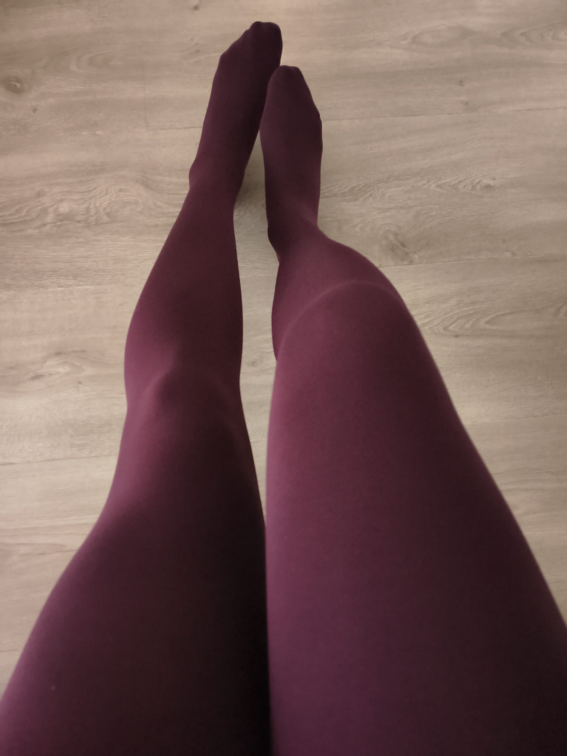 Woman in Yirane burgundy 80D opaque tights, standing, legs straight, on a wooden floor