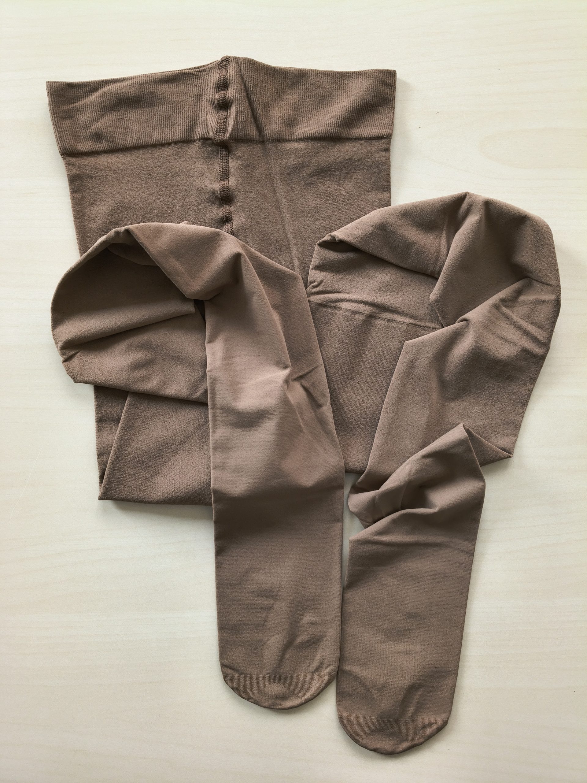 Yirane 80D opaque tights in cocoa brown, folded flat on a wooden floor, straight out of the packaging