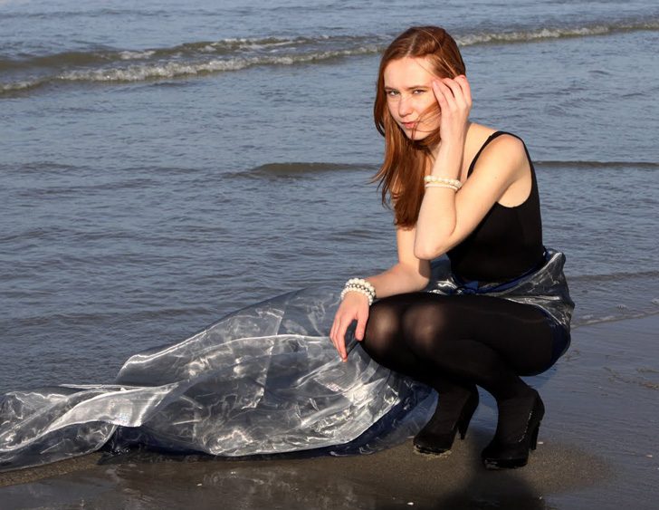 Black pantyhose, dress and heels worn by Saskia van Rij at the beach