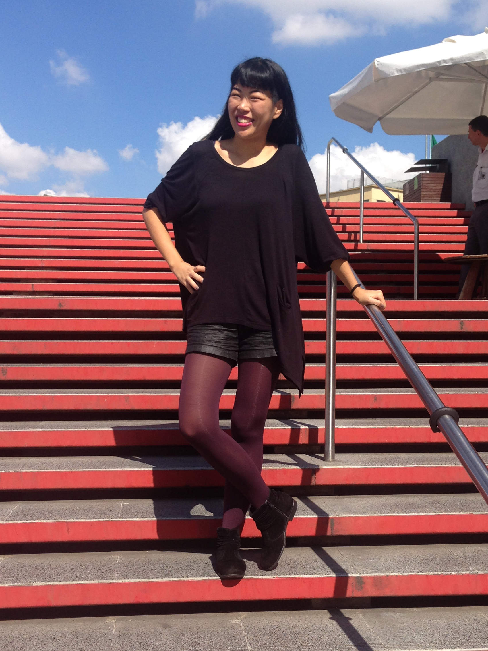 Opaque burgundy pantyhose and black dress worn by Isis Tomie