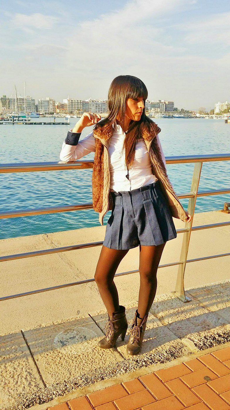 Black tights, blue shorts, white shirt, furry vest and brown high heeled boots worn by Veronica