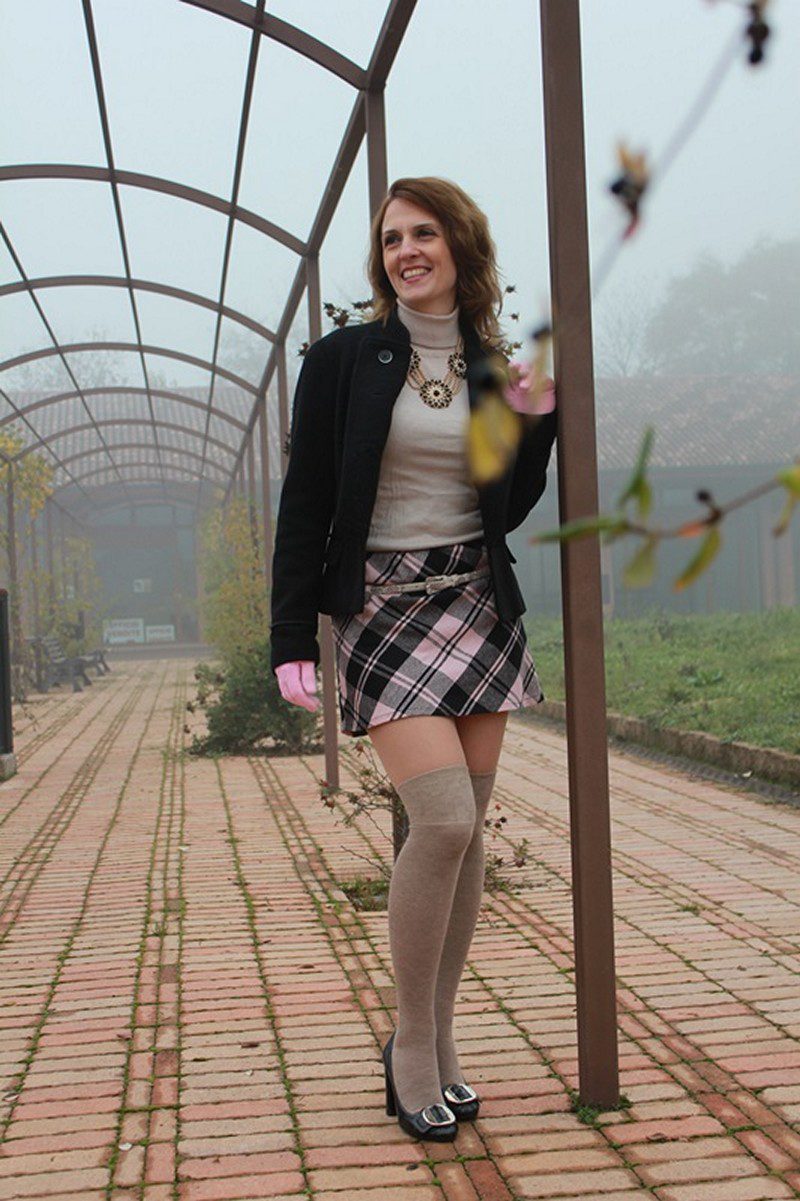 Beige thigh high socks, checkered skirt, beige top and black jacket worn by Margaret