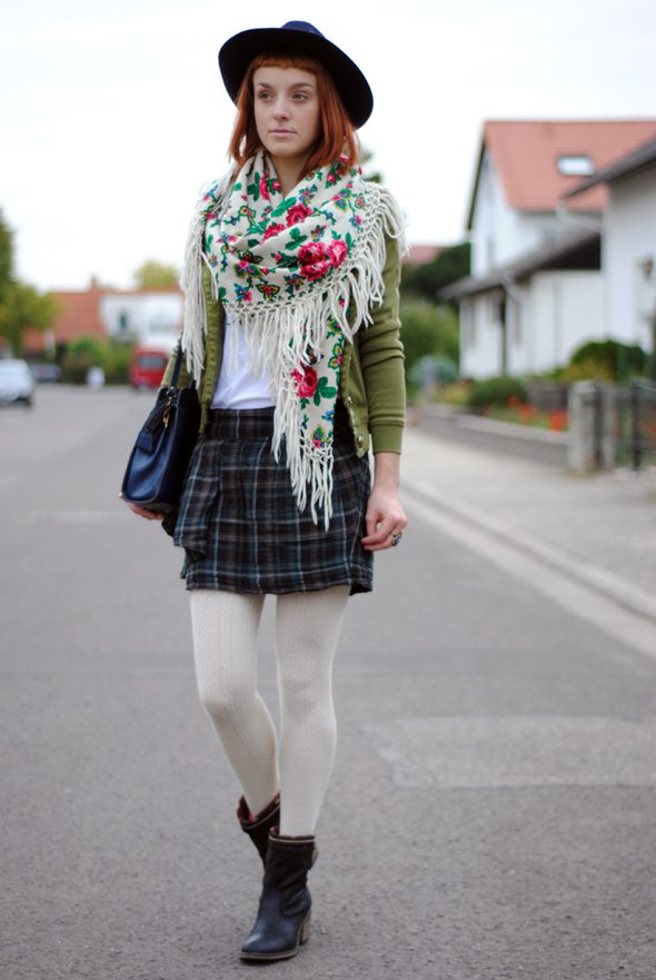 White ribbed wool tights with pleated dark tartan skirt, army green cardigan and flower print scarf worn by Monika Krawczyk